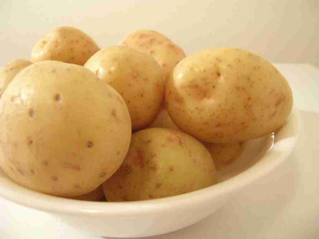 bowl of boiled white potatoes with skins on