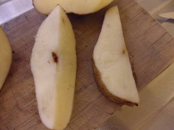 an image of a potato cut in half showing the brown cavity of hollow heart inside