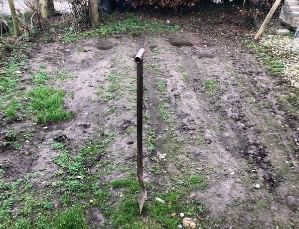 a vegetable garden with a spade dug into the soil